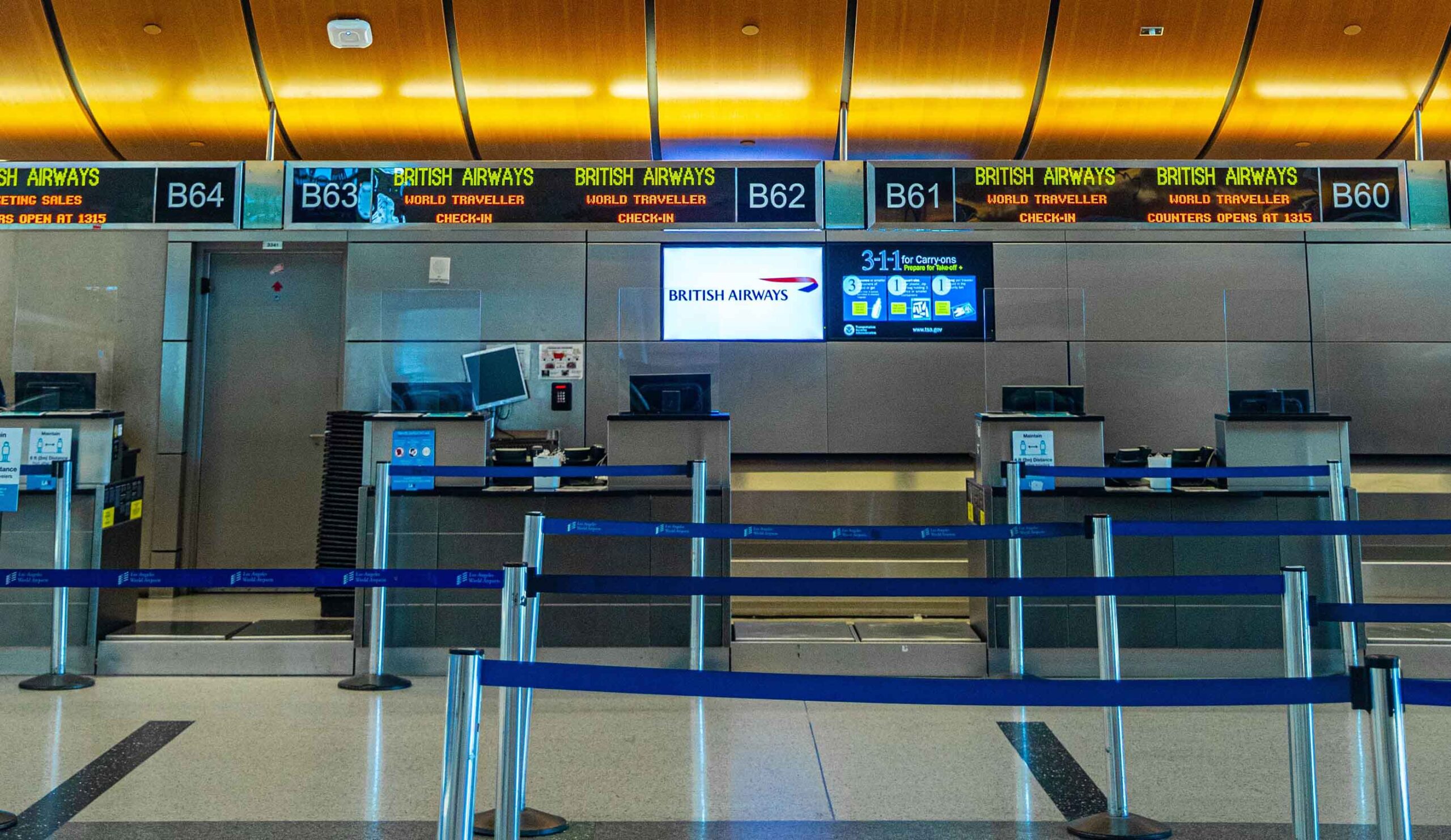 A line of travelers waiting to check in at an airport, with luggage and boarding passes in hand